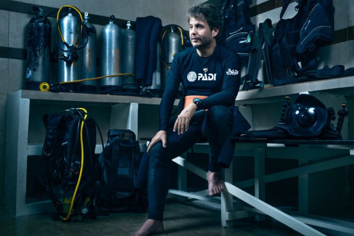 Gerardo del Villar, embajador de PADI, sentado junto a equipo de buceo durante una expedición submarina.